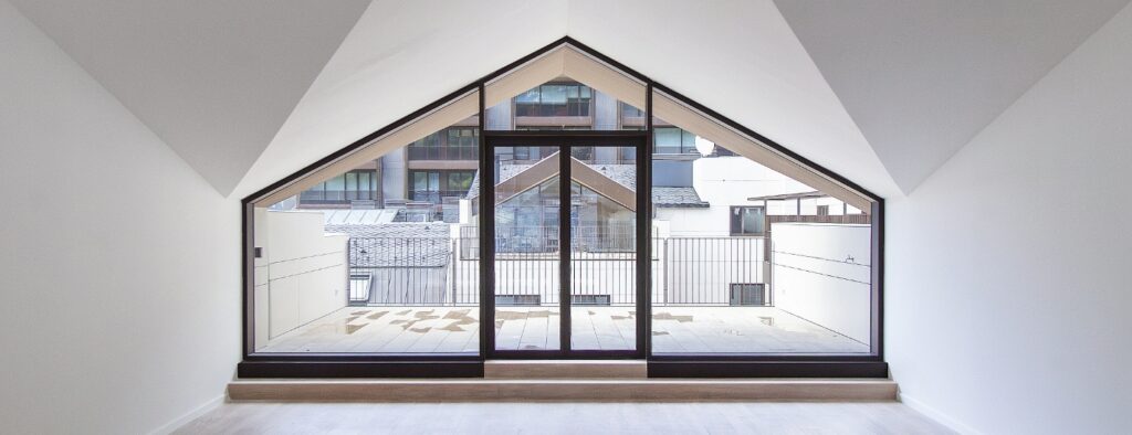 Gran tancament triangular de vidre amb portes integrades a façana